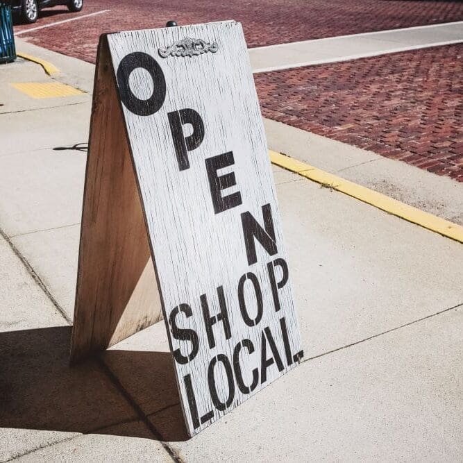 A "shop local" sign outside of a small local business.